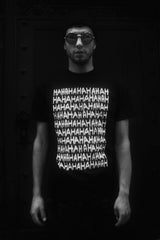 A male model wearing the MIRKKA METSOLA black t shirt with white HAHA print on the front